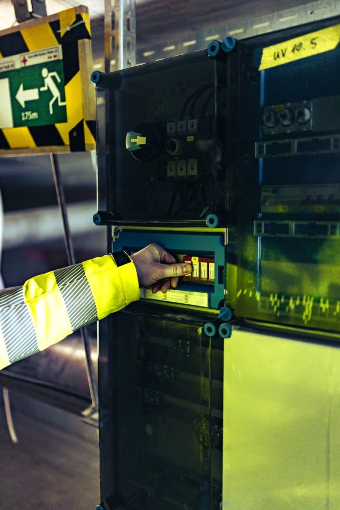 Fachkraft prüft einen elektrischen Schaltschrank